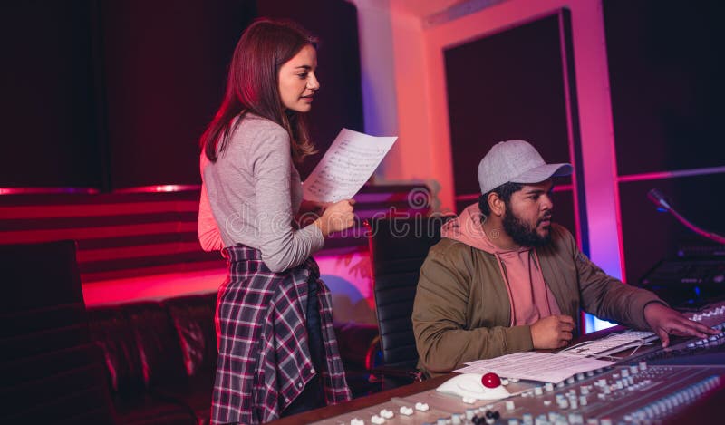 Solida teknikerer som arbetar i musikinspelningstudio arkivfoton Solida teknikerer som arbetar i musikinspelningstudio arkivfoton