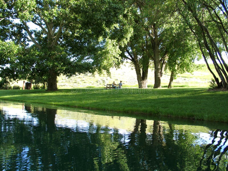 A couple in the far distance enjoying a picnic on a beautiful sunny day. A couple in the far distance enjoying a picnic on a beautiful sunny day.