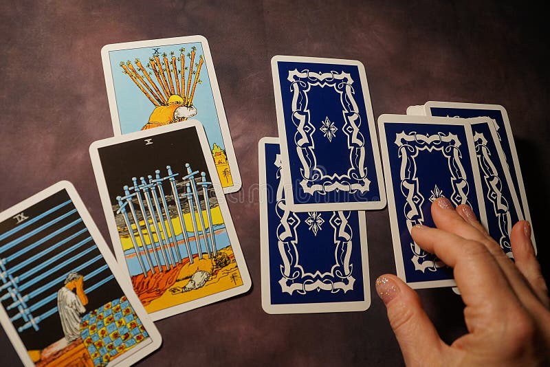 Solitaire layout, female hands spread tarot cards on the table