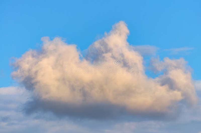 Solitary cloud of torn edges in the evening sky with an orange tint stock images Solitary cloud of torn edges in the evening sky with an orange tint stock images