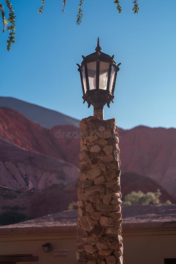 Solitary lamppost stands tall against a backdrop of vibrant, colorful mountains royalty free stock photography