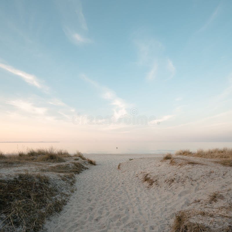 Solitary person on a sand dune at an empty beach royalty free stock images