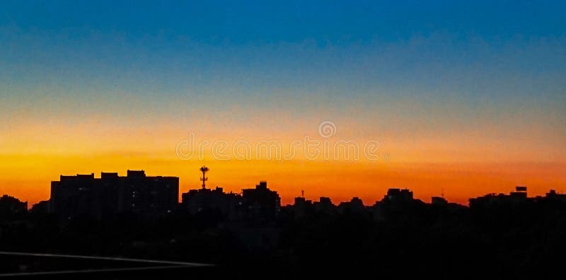 Solnedgång i staden orange och blå timmes himmel fotografering för bildbyråer Solnedgång i staden orange och blå timmes himmel fotografering för bildbyråer