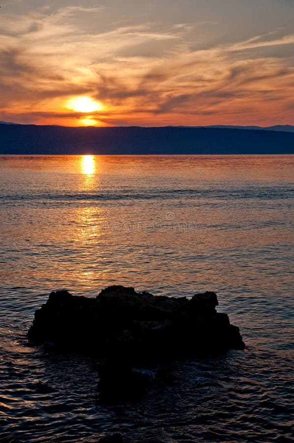 Solnedgång på havet på Glavotok med stenen - Kroatien - Krk royaltyfria foton Solnedgång på havet på Glavotok med stenen - Kroatien - Krk royaltyfria foton
