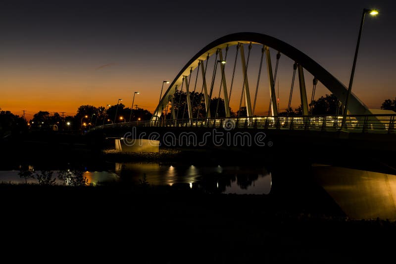 Solnedgången på Main Street band den ärke- upphängningbron över den Scioto floden i Columbus, Ohio royaltyfri foto Solnedgången på Main Street band den ärke- upphängningbron över den Scioto floden i Columbus, Ohio royaltyfri foto