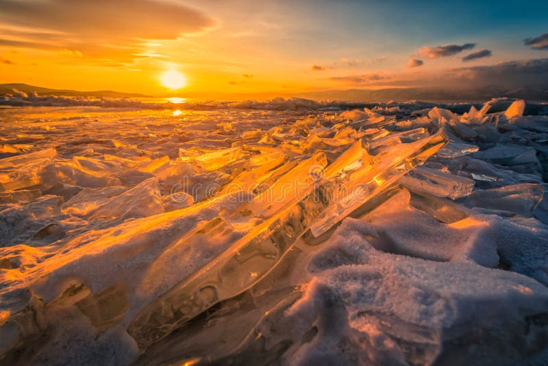 Solnedgånghimmel med naturlig brytande is över djupfryst vatten på Lake Baikal, Sibirien, Ryssland arkivfoto Solnedgånghimmel med naturlig brytande is över djupfryst vatten på Lake Baikal, Sibirien, Ryssland arkivfoto