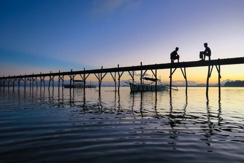 Solnedgångkonturer på pir - Siargao, Filippinerna royaltyfri fotografi Solnedgångkonturer på pir - Siargao, Filippinerna royaltyfri fotografi