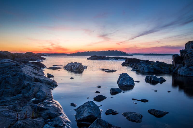 Solnedgångstenar på Ladoga sjön i Karelia, Ryssland royaltyfri bild Solnedgångstenar på Ladoga sjön i Karelia, Ryssland royaltyfri bild