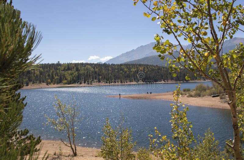 Solsken mousserar på vattnet som en fisheman står på en punkt, och gulnande asp- sidor skimrar på Chrystal Reservoir den halva vä arkivbilder Solsken mousserar på vattnet som en fisheman står på en punkt, och gulnande asp- sidor skimrar på Chrystal Reservoir den halva vä arkivbilder