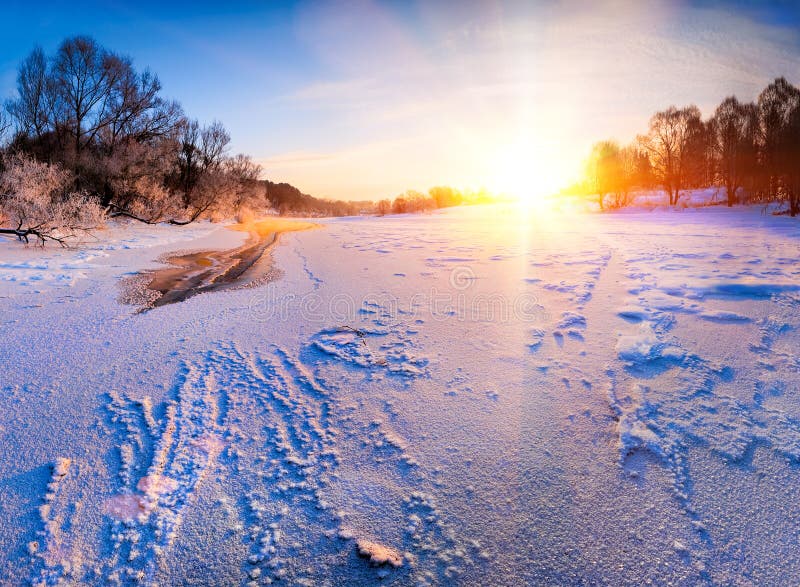 Soluppgång över den djupfrysta floden arkivfoto