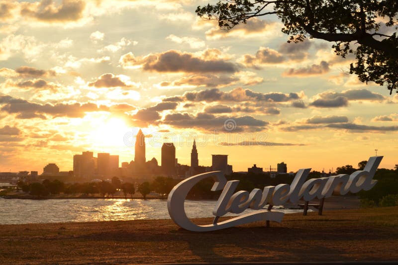 Soluppgång över det Cleveland tecknet och horisont på Lake Erie royaltyfria bilder Soluppgång över det Cleveland tecknet och horisont på Lake Erie royaltyfria bilder