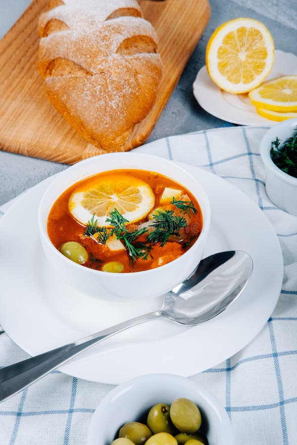 Solyanka en tjock soppa av grönsaker och kött som tjänas som med citronen och oliv arkivfoto Solyanka en tjock soppa av grönsaker och kött som tjänas som med citronen och oliv arkivfoto