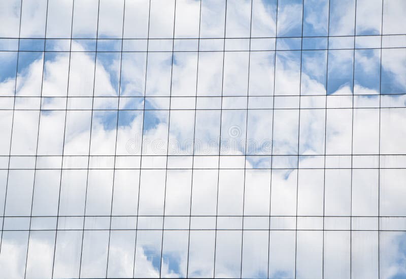 A sombra das nuvens brancas e do céu azul no vidro claro da parede de construção imagem de stock royalty free A sombra das nuvens brancas e do céu azul no vidro claro da parede de construção imagem de stock royalty free