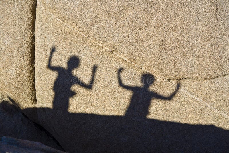 Shadows of two dancing children on a rock in Jushua Tree Nationalpark. Shadows of two dancing children on a rock in Jushua Tree Nationalpark