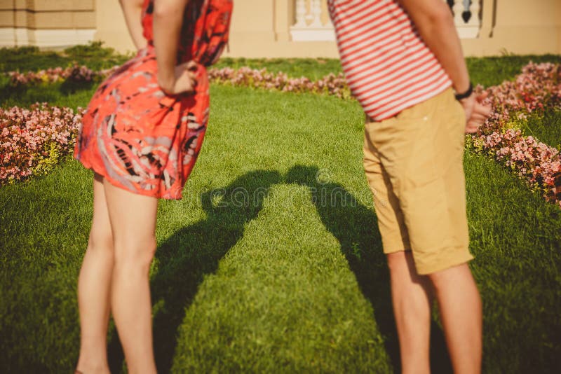 Sombras dos pares de beijo que formam sua silhueta na grama Os pares novos felizes que beijam na flor estacionam fora foto de stock Sombras dos pares de beijo que formam sua silhueta na grama Os pares novos felizes que beijam na flor estacionam fora foto de stock