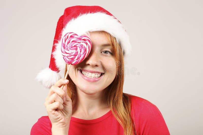 Sombrero femenino del ` s de Papá Noel del pelirrojo que lleva magnífico con el estallido-pom, celebrando días de fiesta festivos fotos de archivo Sombrero femenino del ` s de Papá Noel del pelirrojo que lleva magnífico con el estallido-pom, celebrando días de fiesta festivos fotos de archivo