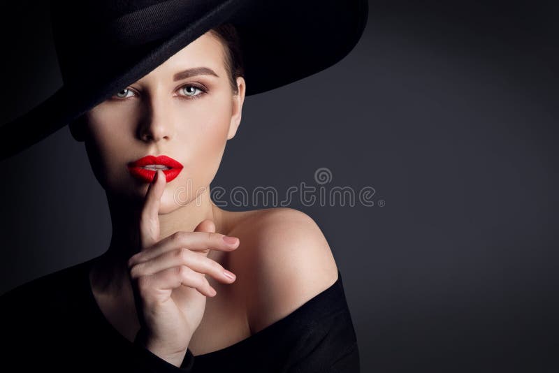 Sombrero negro de la mujer, modelo de moda elegante Beauty Portrait, finger en gesto silencioso de los labios
