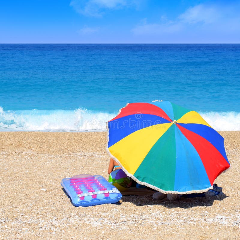 Family on the beach behind the sunshade. Family on the beach behind the sunshade