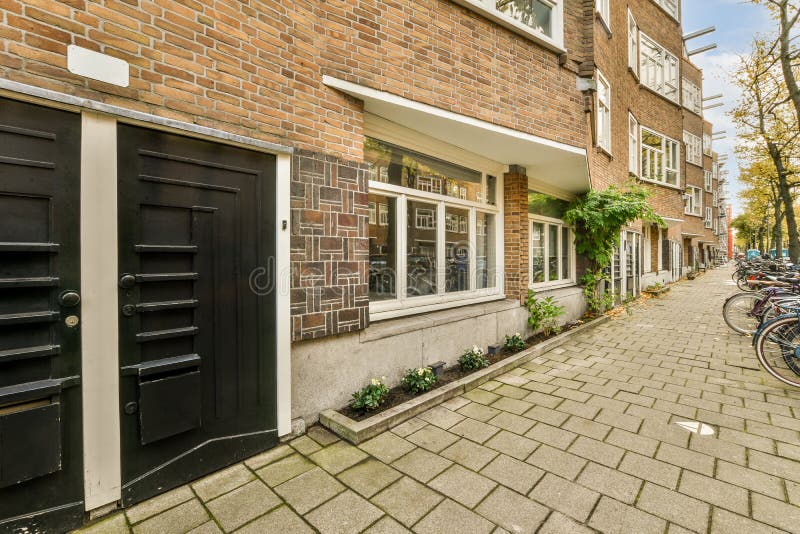 A Brick House with a Black Door and a Sidewalk Stock Photo Image of
