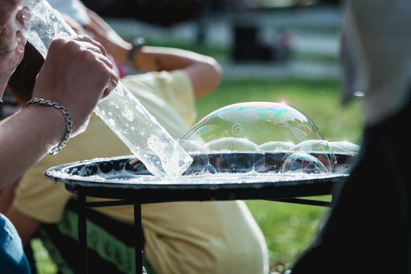 Someone playing blowing and making soap bubbles on a plate royalty free stock images