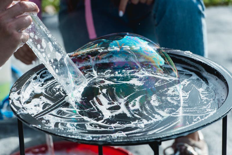 Someone playing blowing and making soap bubbles on a plate royalty free stock image