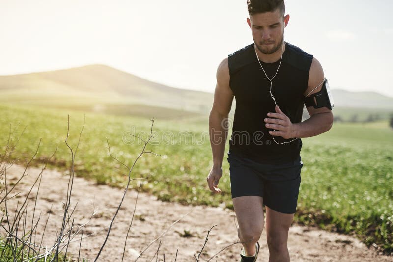 Sometimes youve gotta take the scenic route to fitness. a handsome young man running outdoors. royalty free stock photos