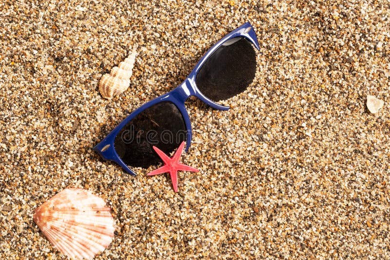 Summer background with sunglasses, seashells and starfish on sand. Summer background with sunglasses, seashells and starfish on sand