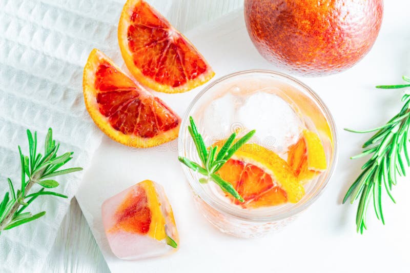 Sommardrink med blodapelsinen och rosmarin p? vit tr?bakgrund L?genhet-lekmanna- b?sta sikt royaltyfria foton Sommardrink med blodapelsinen och rosmarin p? vit tr?bakgrund L?genhet-lekmanna- b?sta sikt royaltyfria foton