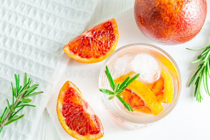 Sommardrink med blodapelsinen och rosmarin p? vit tr?bakgrund L?genhet-lekmanna- b?sta sikt royaltyfria bilder Sommardrink med blodapelsinen och rosmarin p? vit tr?bakgrund L?genhet-lekmanna- b?sta sikt royaltyfria bilder