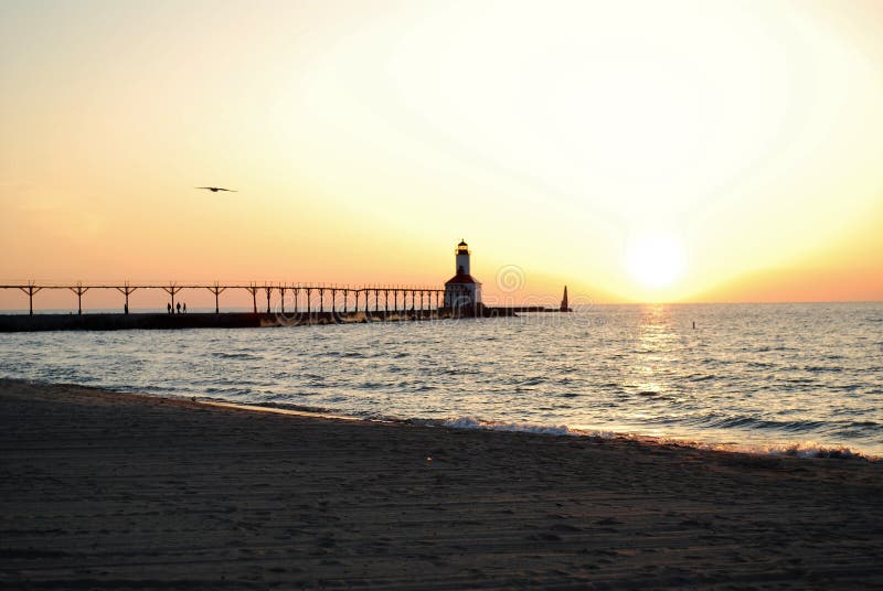 Sommarsolnedgång över fyren på Lake Michigan i den michigan staden indiana arkivbilder Sommarsolnedgång över fyren på Lake Michigan i den michigan staden indiana arkivbilder