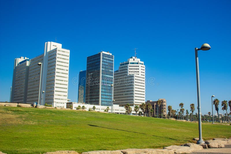 Sommartid Tel Aviv Israels huvudstadsmarkering, stadsfoto med grönt gräs, fyrkantsgata och skyskra royaltyfri foto