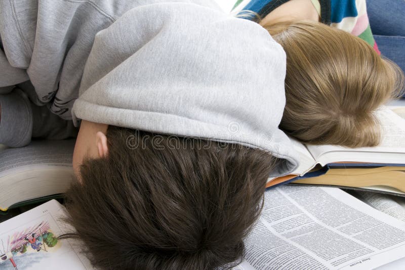 Sommeil fatigué de deux étudiants sur des livres images stock Sommeil fatigué de deux étudiants sur des livres images stock