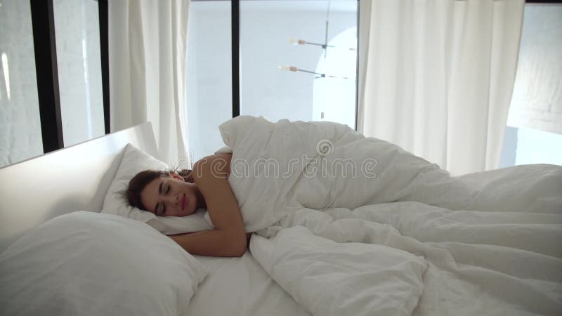 Sommeil Femme dormant dans le lit avec la literie blanche à la chambre à coucher légère clips vidéos