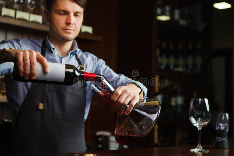 Sommelier dolewania wino w szkło od dekantatoru męski kelner fotografia stock Sommelier dolewania wino w szkło od dekantatoru męski kelner fotografia stock