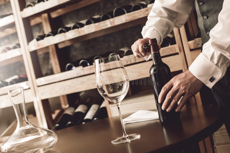 Sommelier-koncept Högre man som står upp och öppnar vinflaskor arkivbilder Sommelier-koncept Högre man som står upp och öppnar vinflaskor arkivbilder