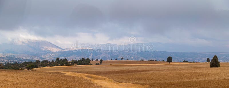 Sommeransicht des gepflogenen Feldes und Berge sind herein an einem teils bewölkten weit lizenzfreie stockfotos Sommeransicht des gepflogenen Feldes und Berge sind herein an einem teils bewölkten weit lizenzfreie stockfotos