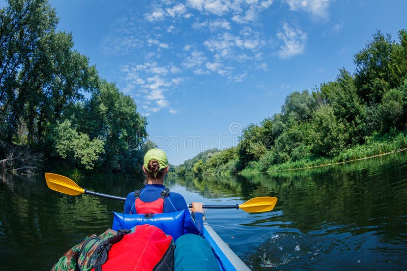 Sommerferien - glückliches Mädchen, das auf Fluss Kayak fährt lizenzfreies stockbild Sommerferien - glückliches Mädchen, das auf Fluss Kayak fährt lizenzfreies stockbild