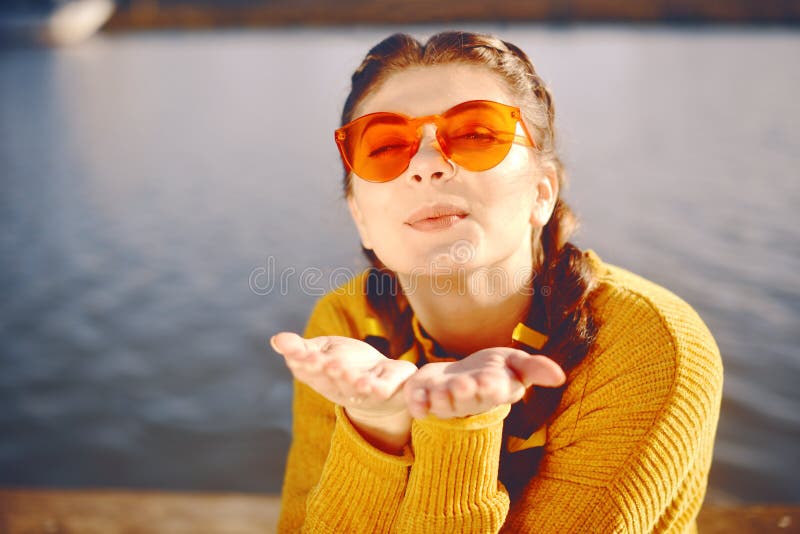 Sommerferienkonzept - glückliche Frau sendet süßen Luftkuß Positives Porträt Sprint der glücklichen netten jungen Frau Tragen gel lizenzfreies stockbild Sommerferienkonzept - glückliche Frau sendet süßen Luftkuß Positives Porträt Sprint der glücklichen netten jungen Frau Tragen gel lizenzfreies stockbild