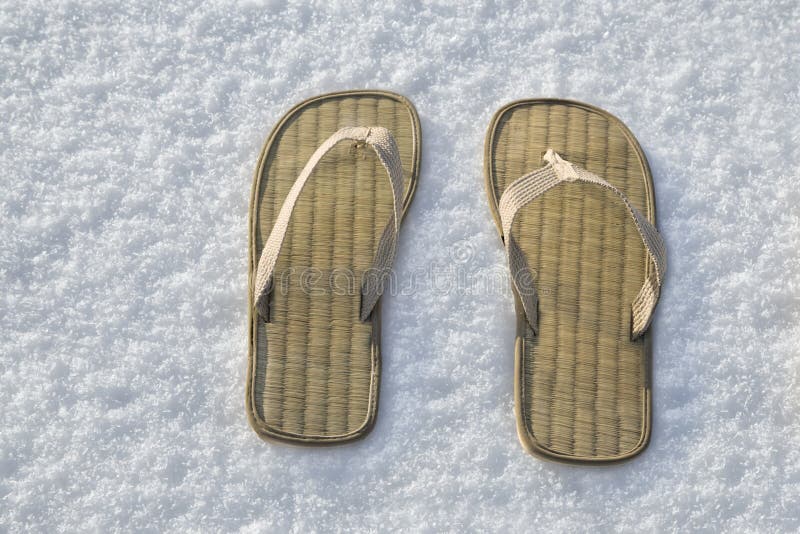 Close view of summer flip flop sandals on the white snow. Close view of summer flip flop sandals on the white snow