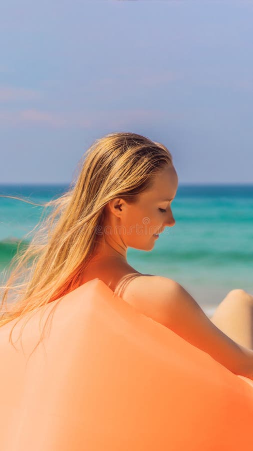 Sommerlebensstilporträt des hübschen Mädchens sitzend auf dem orange aufblasbaren Sofa auf dem Strand von Tropeninsel Entspannung stockbilder Sommerlebensstilporträt des hübschen Mädchens sitzend auf dem orange aufblasbaren Sofa auf dem Strand von Tropeninsel Entspannung stockbilder