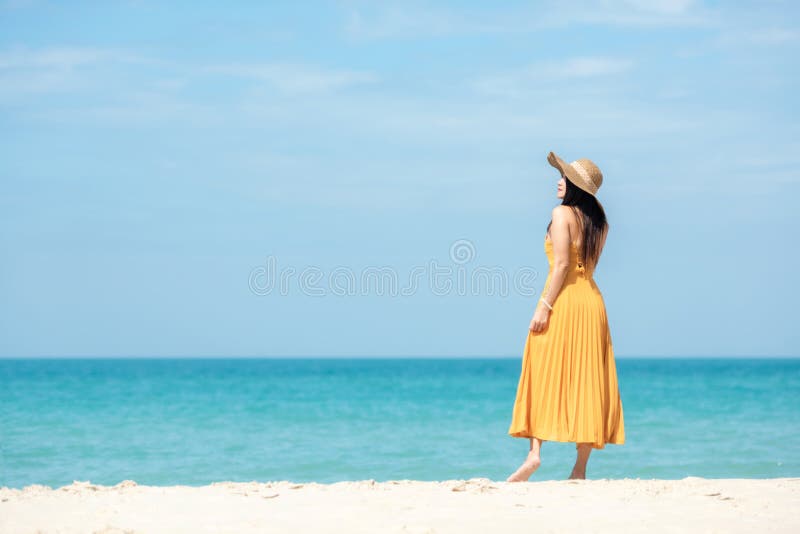 Sommerurlaub Lifestyle-Frau Chille mit gelber Kleidung Mode Sommerausflüge stehen Chiles auf dem sandigen Strand des Ozeans