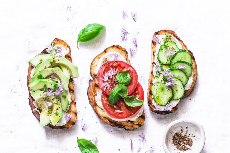 Sommerveränderungen von Sandwichen - mit Sahne Käse, Avocado, Tomate und Gurke auf einem hellen Hintergrund, Draufsicht Gesunde D stockfotos Sommerveränderungen von Sandwichen - mit Sahne Käse, Avocado, Tomate und Gurke auf einem hellen Hintergrund, Draufsicht Gesunde D stockfotos