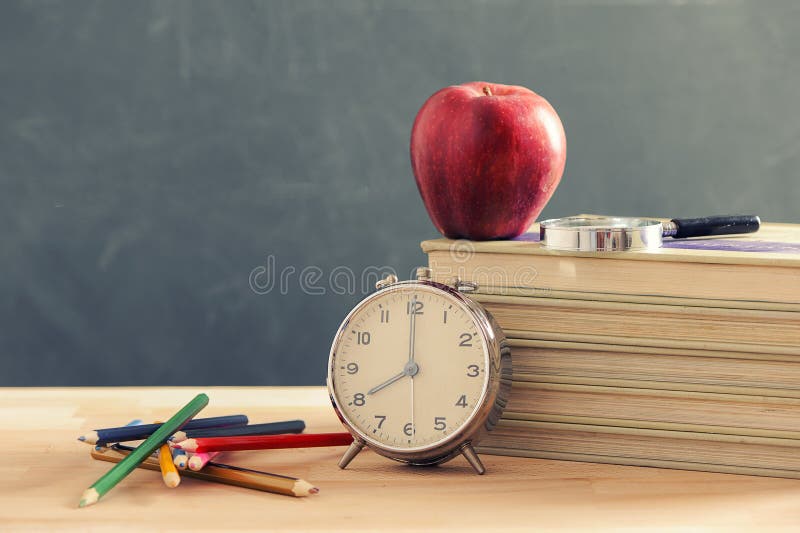 Sommige boeken en een potloodhouder op een houten lijst Een sappige rode appel bevindt zich op de boeken De rode appel bevindt zi stock afbeeldingen Sommige boeken en een potloodhouder op een houten lijst Een sappige rode appel bevindt zich op de boeken De rode appel bevindt zi stock afbeeldingen