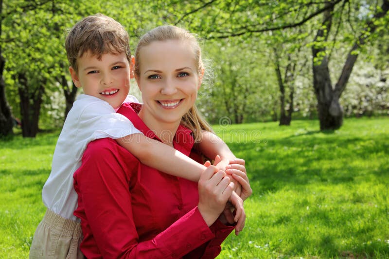 Son embraces behind mother in park