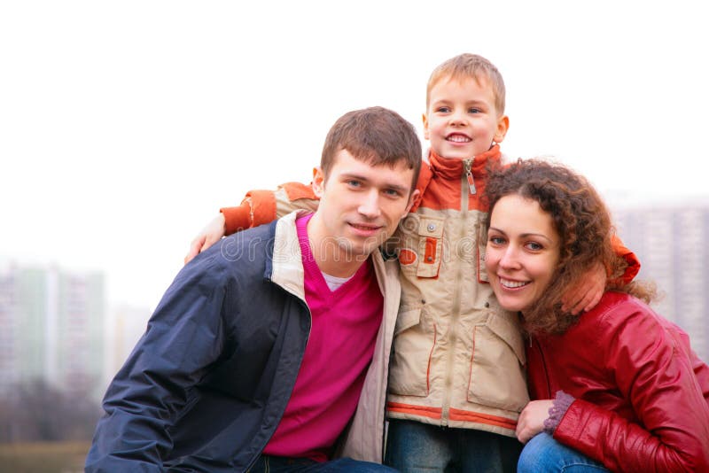 Son embraces parents outdoor in city