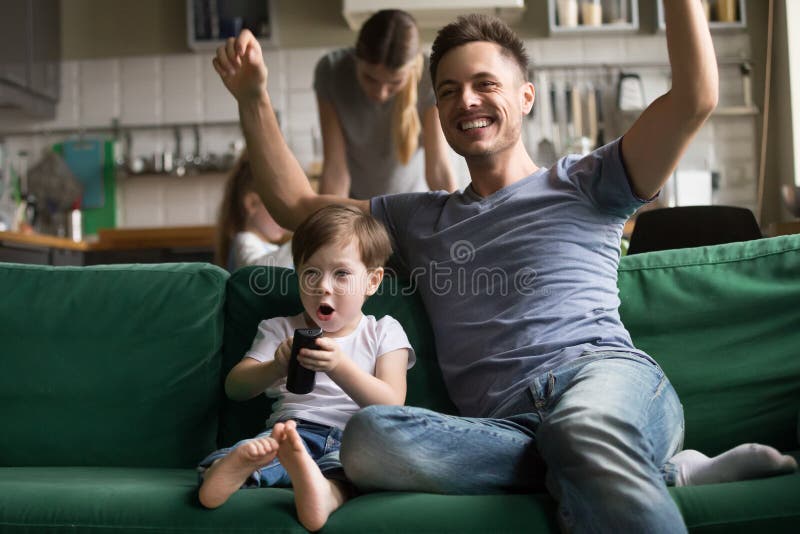 Son with father watching football on TV together