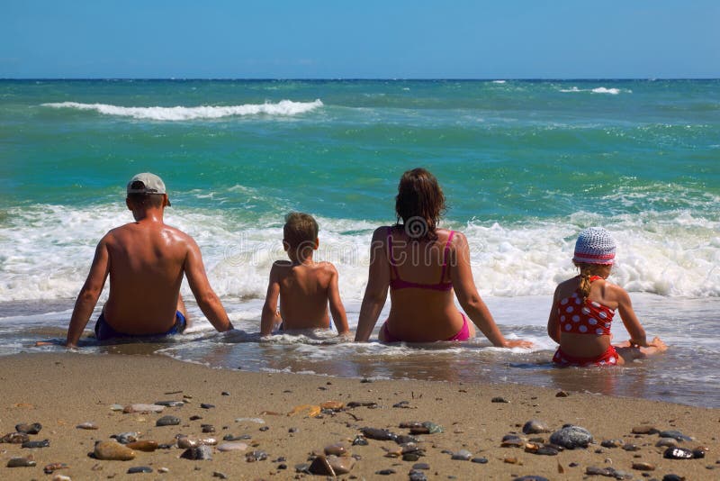 Son för moder för stranddotterfader sittande royaltyfri foto