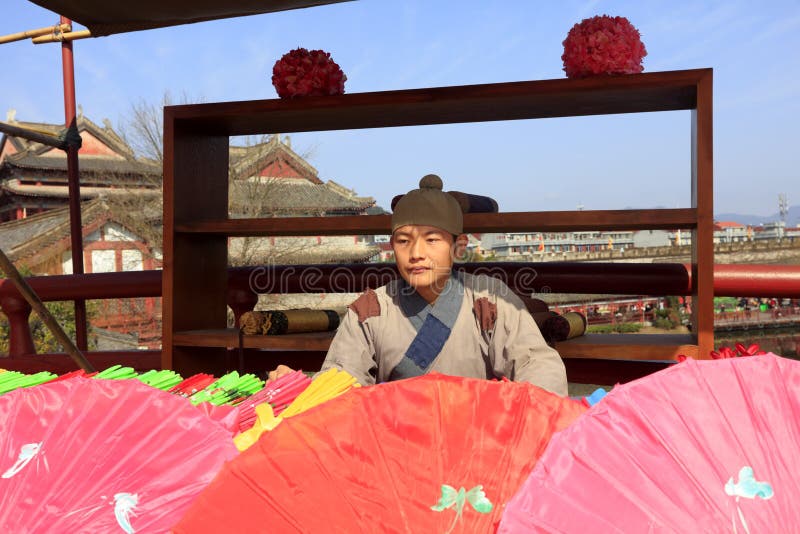 Song Dynasty poor hawkers selling colored umbrella in hengdian studios, adobe rgb royalty free stock images Song Dynasty poor hawkers selling colored umbrella in hengdian studios, adobe rgb royalty free stock images