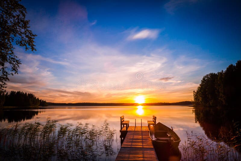 Sonnenaufgang über dem Fischenpier am See in Finnland stockbild Sonnenaufgang über dem Fischenpier am See in Finnland stockbild