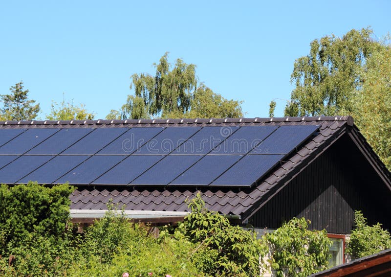 Sonnenkollektor auf Hausdach mit blauem Himmel